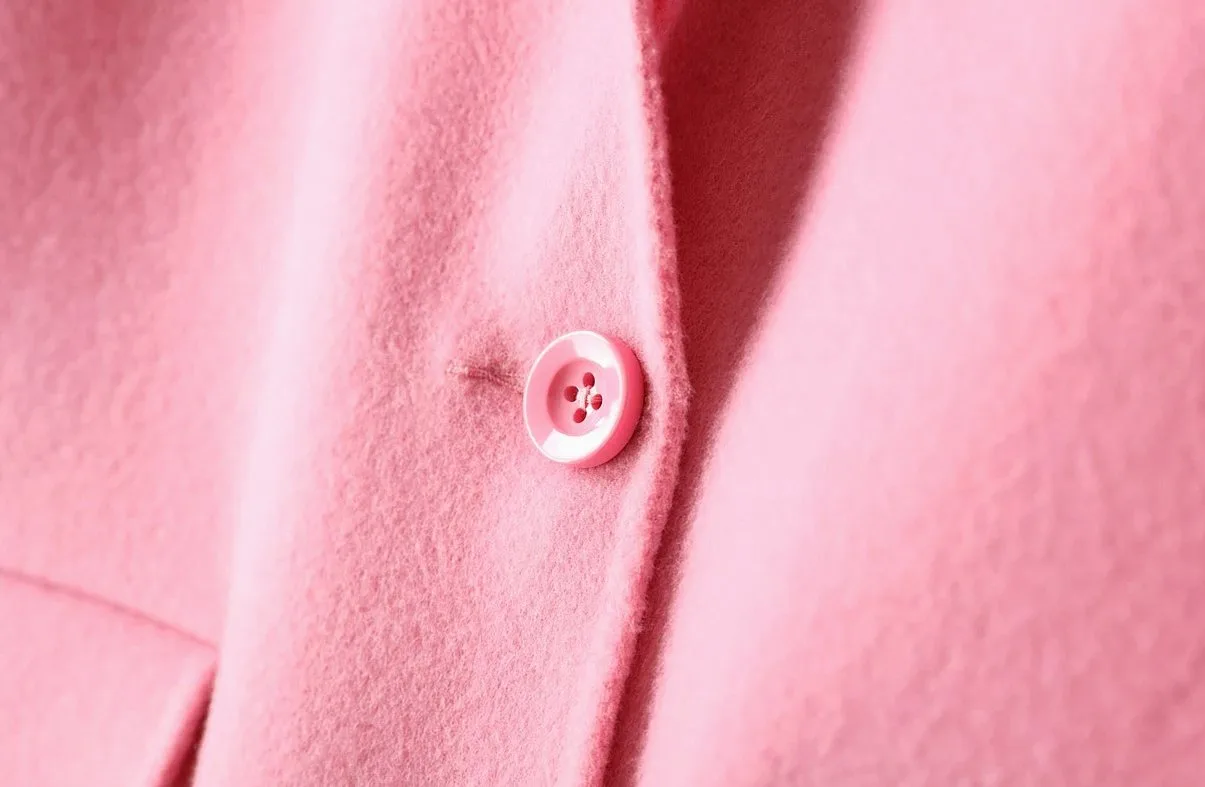 Close-up of a pink wool coat with a single pink button