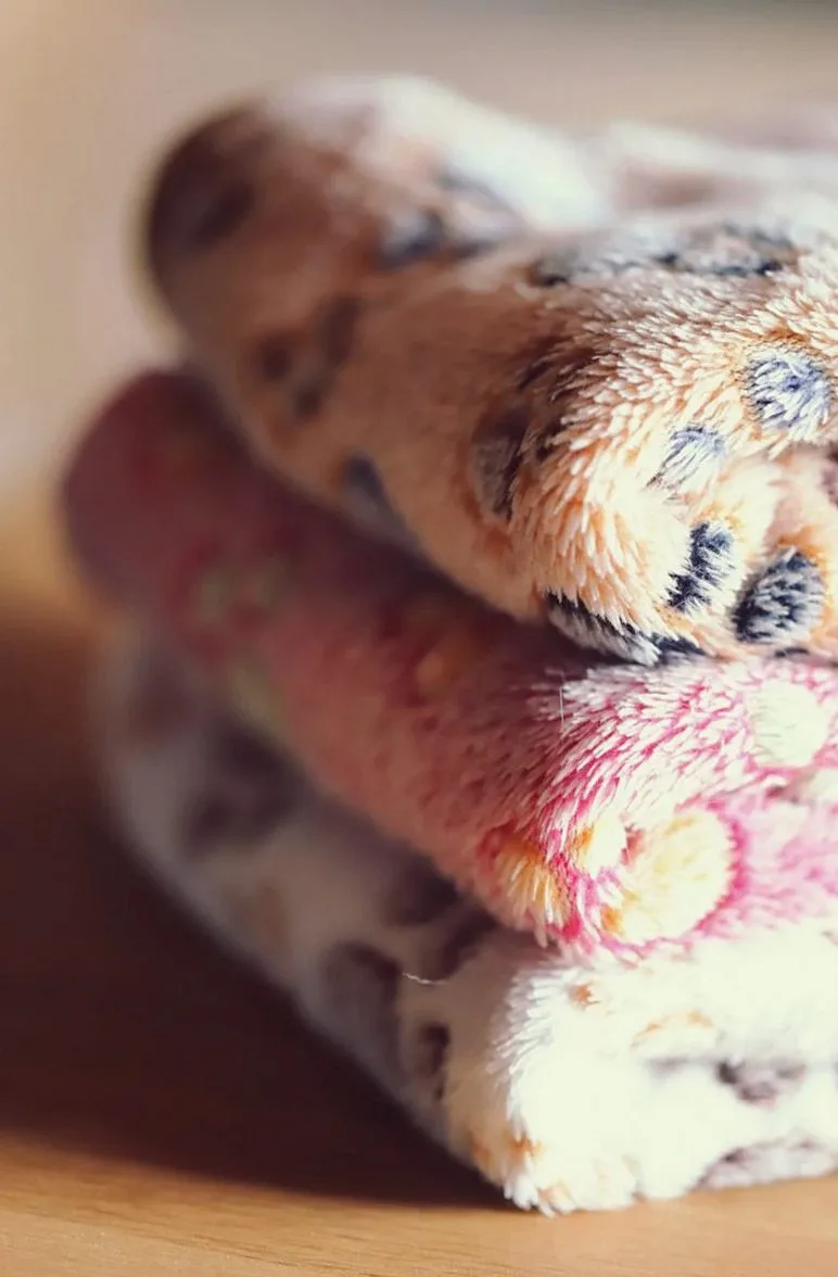 Stack of folded soft blankets with an animal-print pattern